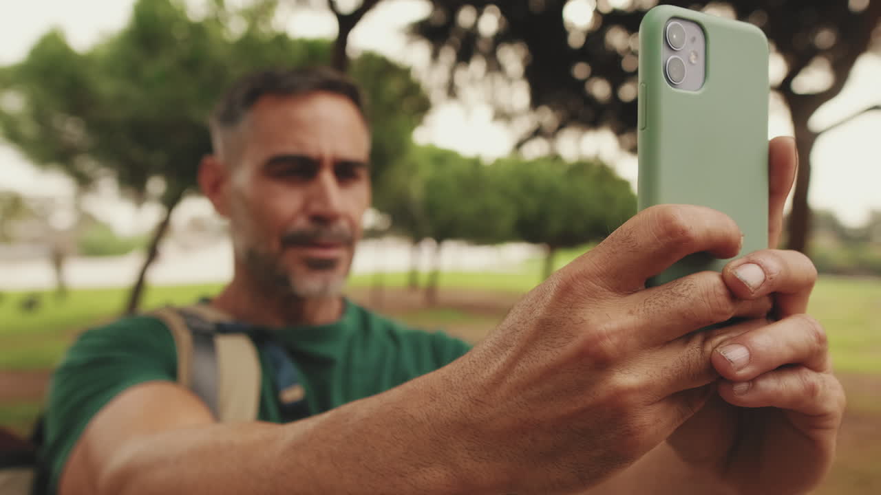 Homem tirando uma selfie em um parque