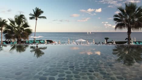 Oceanfront-Cabo-San-Lucas-resort-with-palm-trees-and-scenic-view-of-ocean