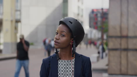 portrait young professional african american business woman wearing helmet puts on earphones listening to music using smartphone in city ready to travel