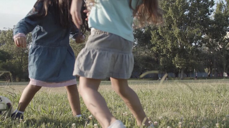 Bambini felici che giocano a calcio all'aperto