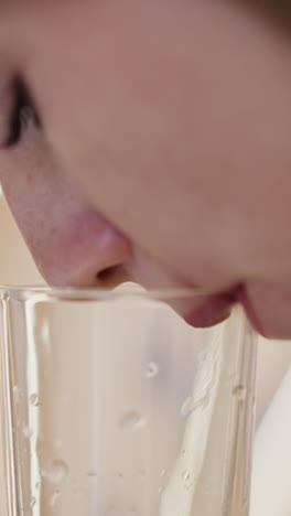 woman with closed eyes enjoys drinking water from glass on blurred background. thirsty lady keeps water balance for wellbeing closeup slow motion