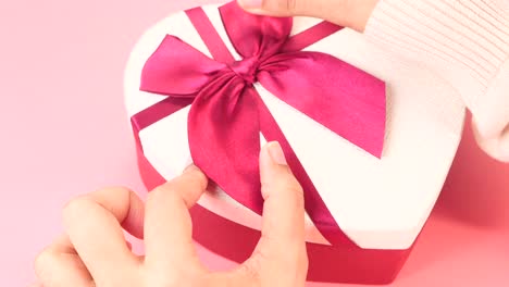 woman opening a heart-shaped gift box