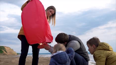 family launching a sky lantern on the beach