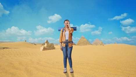 full body of asian female hiker with mountaineering backpack smiling and showing ok sign with fingers over eyes while traveling in pyramid of giza