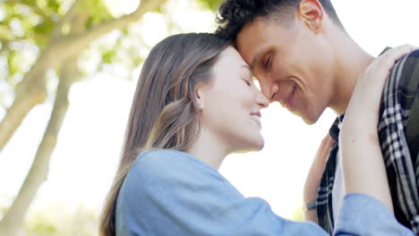 Happy-diverse-couple-embracing-in-sunny-garden,-in-slow-motion