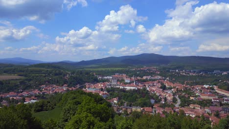 Majestuosa-Vista-Aérea-Superior-Vuelo-Montaña-Descripción-General-Colina-Ciudad-Panorama,-Krumlov-República-Checa-Verano-2023