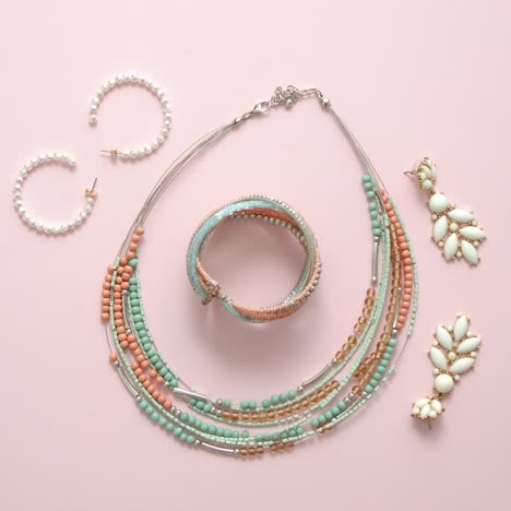 Woman-fashion-accessories--Jewelry--Earings-and-necklace-on-stylish-pastel-pink-background--Flat-lay