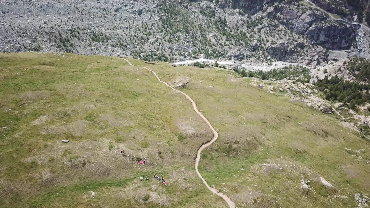Grassery meadow in the Swiss alps, drone view of a valley in the mountains, hiking paths for walkers, bikers, ressourcing landscape