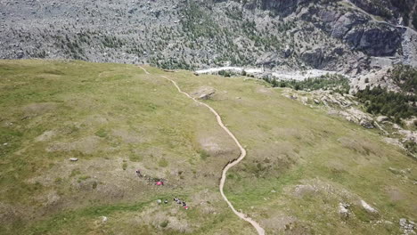 grassery meadow in the swiss alps, drone view of a valley in the mountains, hiking paths for walkers, bikers, ressourcing landscape