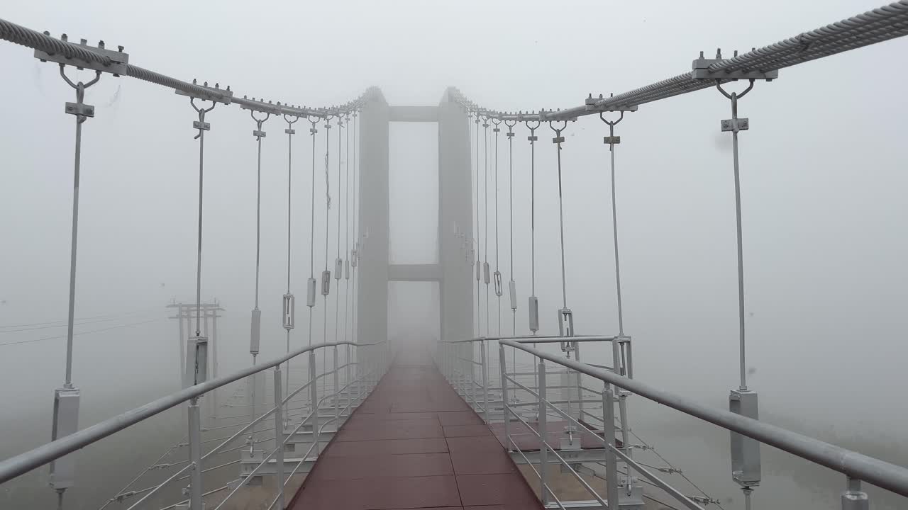 A vast, deserted iron bridge shrouded in fog.