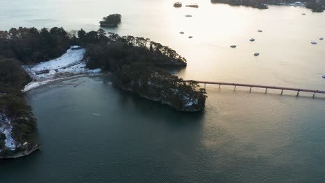 Antena-De-La-Bahía-De-Matsushima,-Nieve-Al-Atardecer-Sobre-La-Isla-De-Fukuurajima,-Miyagi-Japón