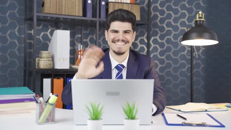 Young-businessman-waving-and-talking-to-the-camera.