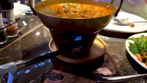 preparing spicy prawn soup with a flame