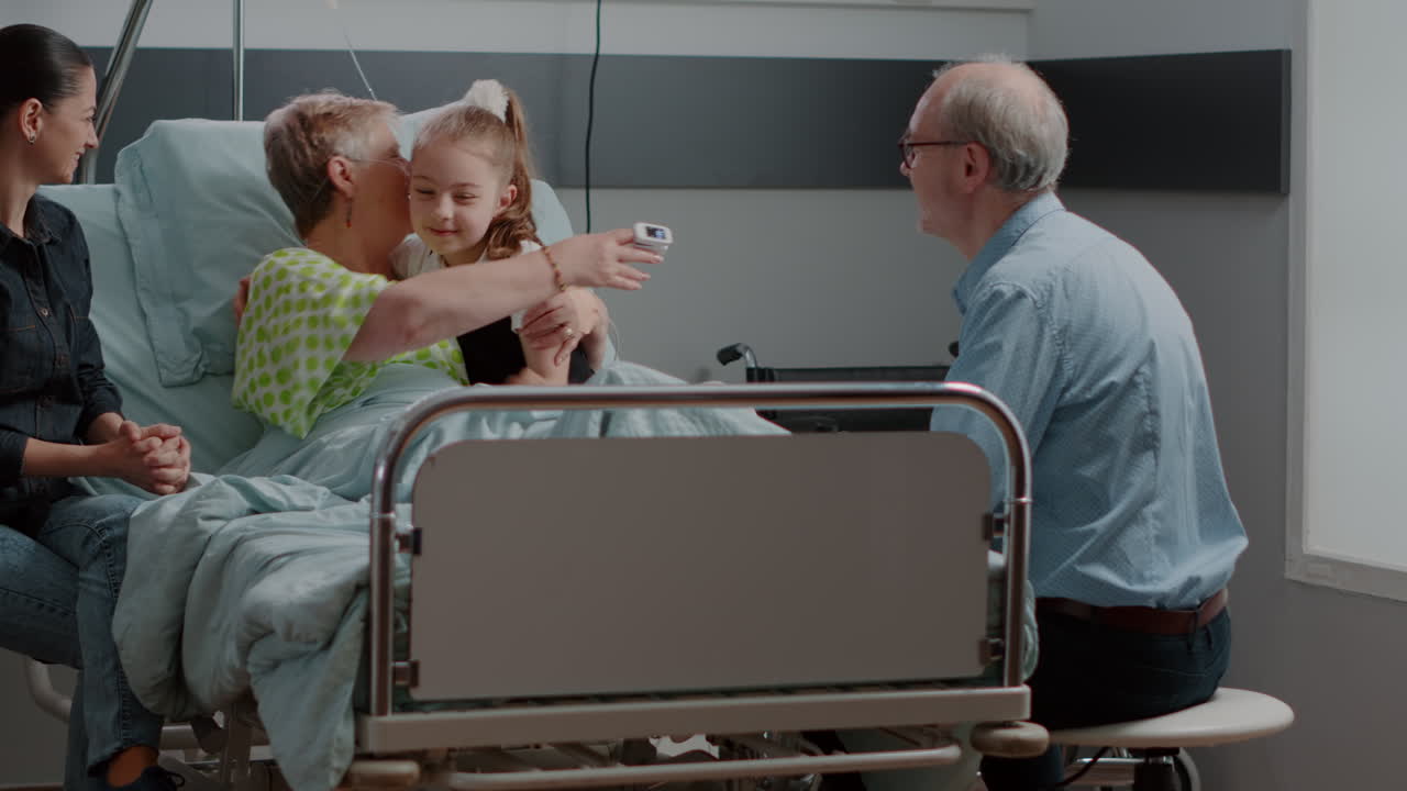 Kid hugging sick grandma at family visit in hospital ward