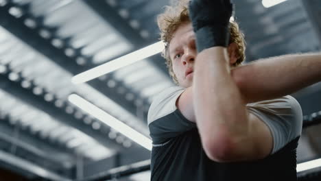 Eager-sportsman-checking-up-hands-at-gym.-Fighter-getting-ready-for-battle