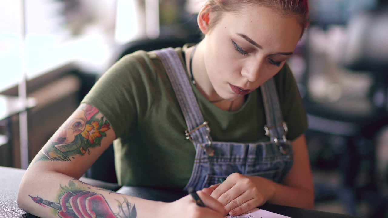 Woman Tattoo Artist Working on a Design