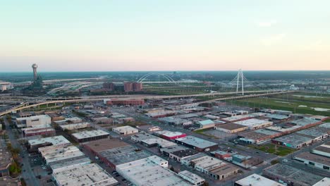 drone footage of low buildings in a busy city with a white bridge in the background