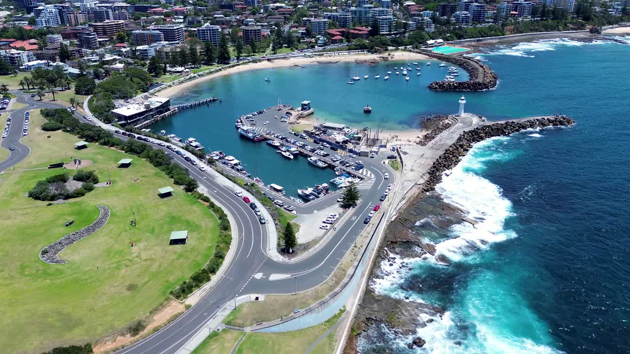 Drone aerial landscape of main road near Wollongong Breakwater Lighthouse bay inlet with Cove Beach along city foreshore waterfront headland and coastline in Illawarra NSW Australia marine tourism
