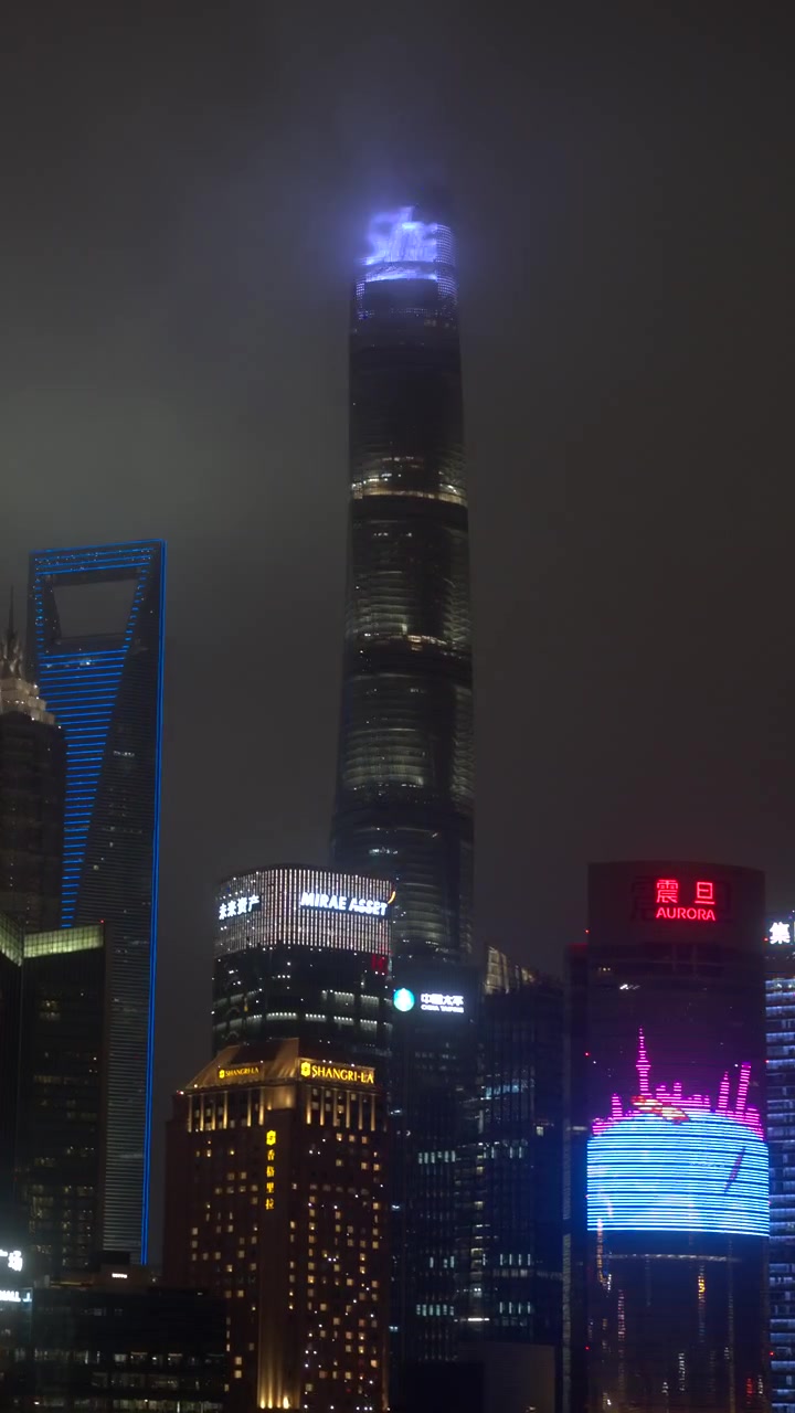 Torre de Xangai iluminada à noite em tempo nebuloso