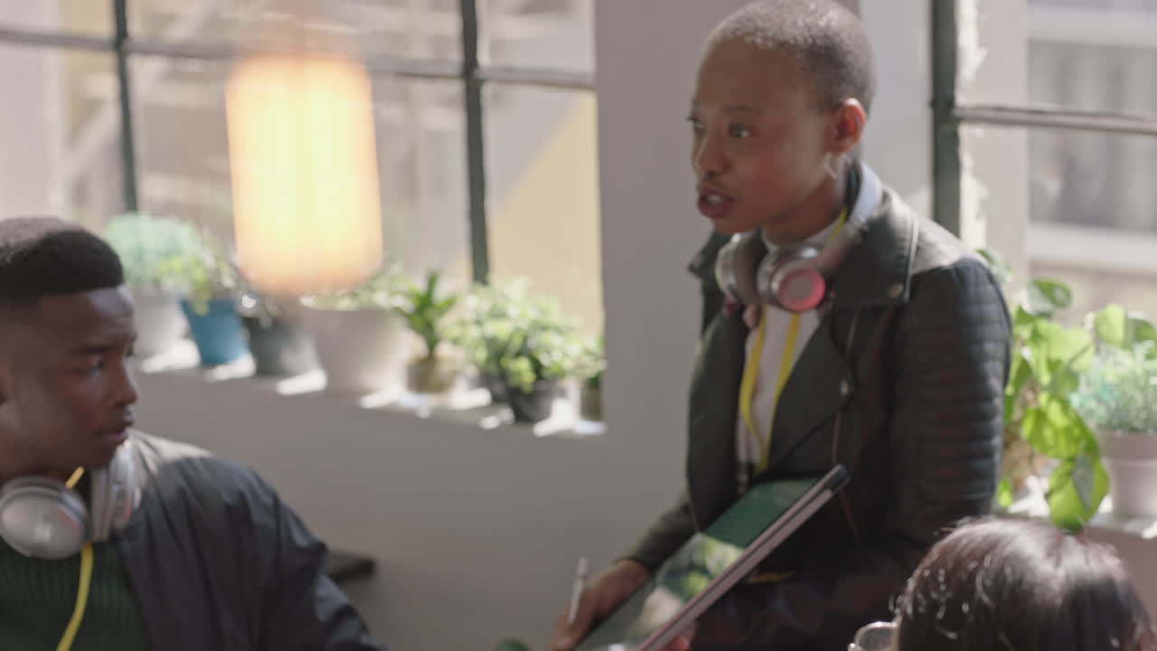 jeunes hommes d'affaires rencontrent un chef d'équipe afro-américain femme utilisant une tablette montrant des idées de projets créatifs sur l'écran stratégie de partage collègues collaborant dans une séance d'information au bureau