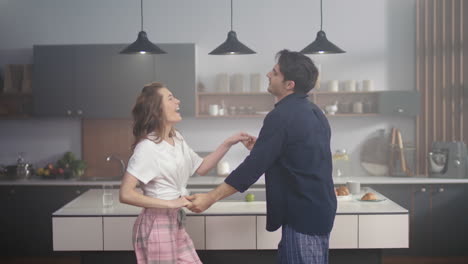 Pareja-Riendo-Bailando-En-La-Cocina-Doméstica.-Dos-Personas-Disfrutando-Del-Tiempo-Juntas.