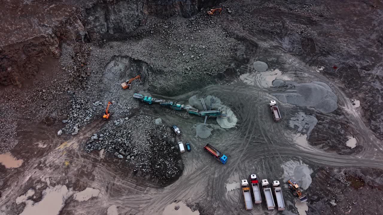Granite quarry in operation with heavy machinery and trucks at work