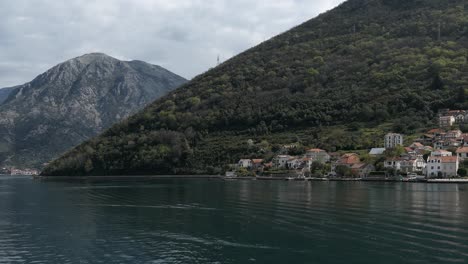 Pueblo-Costero-Con-Techos-Rojos-Junto-A-Las-Montañas-Y-El-Mar,-Montenegro