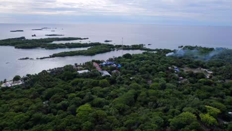 isla tropical al atardecer mientras la gente local practica la quema de madera y paja