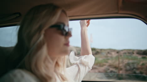 carefree girl riding automobile putting hand in open window closeup. driving car