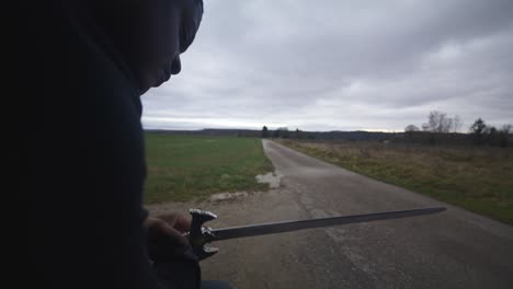 Guerrero-Espadachín-Negro-Moderno-Esperando-Oponente-De-Batalla-En-Campo-Abierto-Bajo-Un-Cielo-Gris,-Europa,-4k-|-Musculoso,-Intimidante,-Sombra,-Figura,-Borroso,-Ropa-Oscura,-Poderoso,-De-Cerca,-Examinar,-Preparar