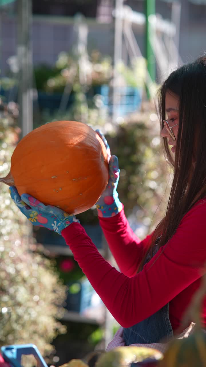 mujer sosteniendo una calabaza en un jardín