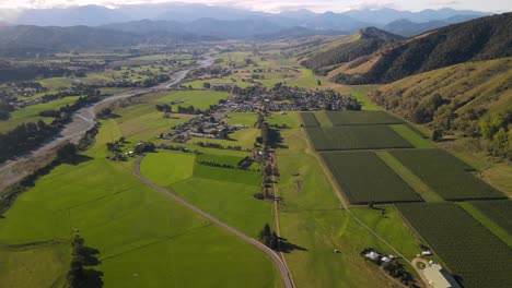 Hermosa-Vista-Aérea-Del-Valle-De-Motueka,-La-Ciudad-De-Tapawera,-El-Río-Y-Las-Montañas-En-El-Horizonte,-Nueva-Zelanda