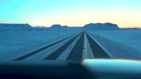 Driving-on-icy-roads-in-Iceland-in-the-winter-towards-the-sunrise-in-February