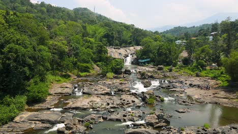 aerial drone shot of munnar’s majestic waterfall surrounded by verdant forests