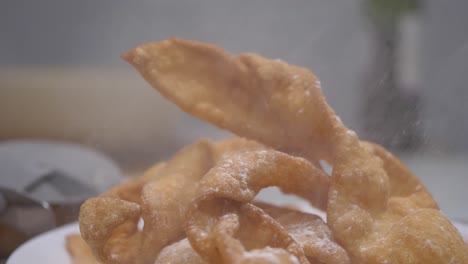 sprinkling compound powder on homemade faworki polish wings