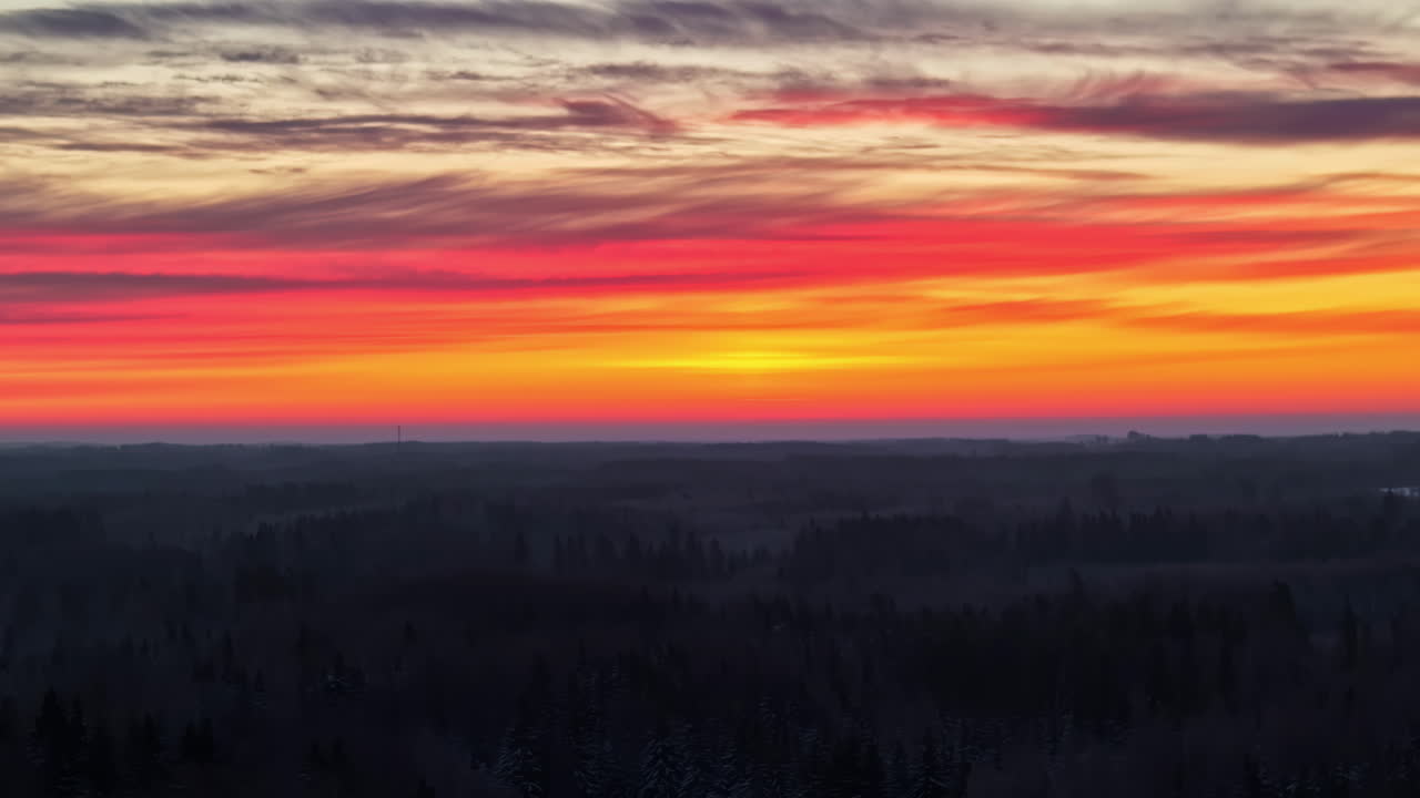 Vibrant red and orange sunset over dark horizon, intense gradient sky from above, natural backdrop