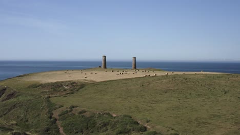 aerial flight over hay fields to cattle below nautical guide towers