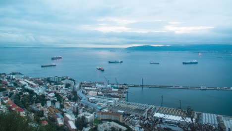 Moving-vessels-near-port-of-Gibraltar,-time-lapse-view-with-stormy-clouds