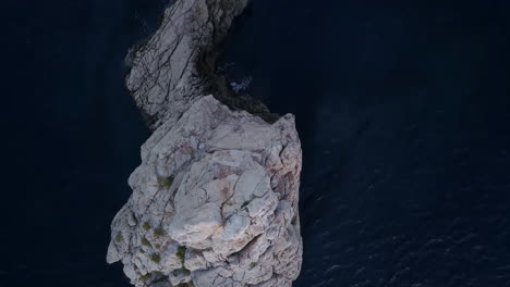 top view dron travelling shot of benirrás rock getting really close to the edge with a cinematic style 4k prores