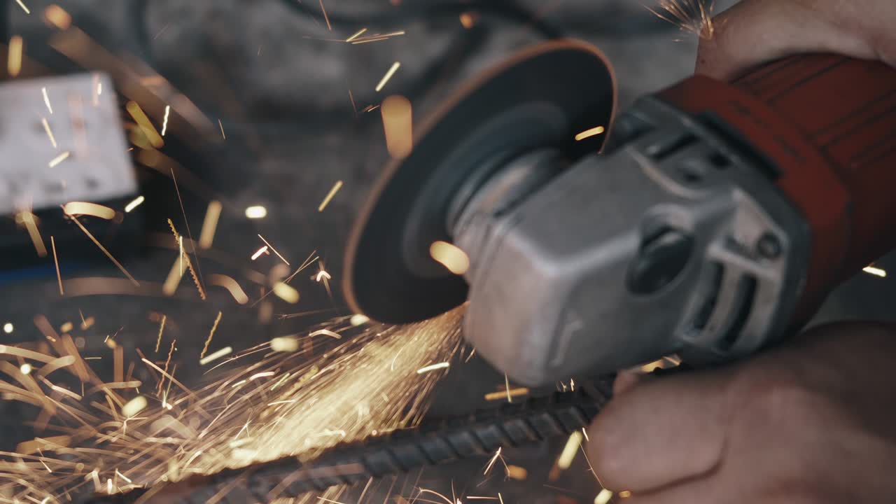 рабочий человек, использующий электрическое колесо для шлифования и резки стальной конструкции