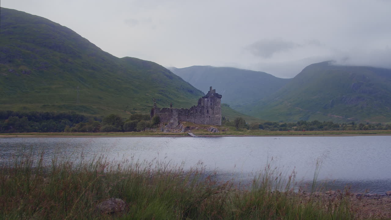 paisaje tranquilo con el castillo de kilchurn en loch awe en escocia - plano amplio y estático