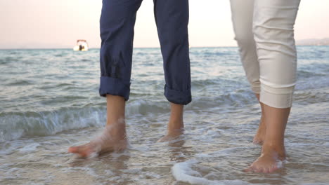 couple walking in incoming sea waves