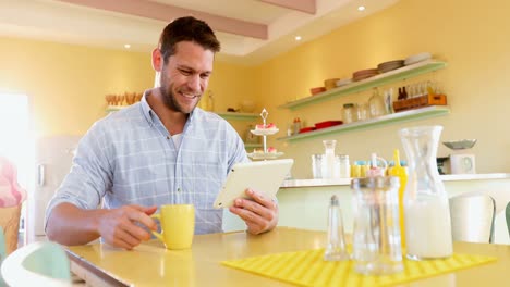 hombre usando tableta digital mientras toma café en el restaurante 4k