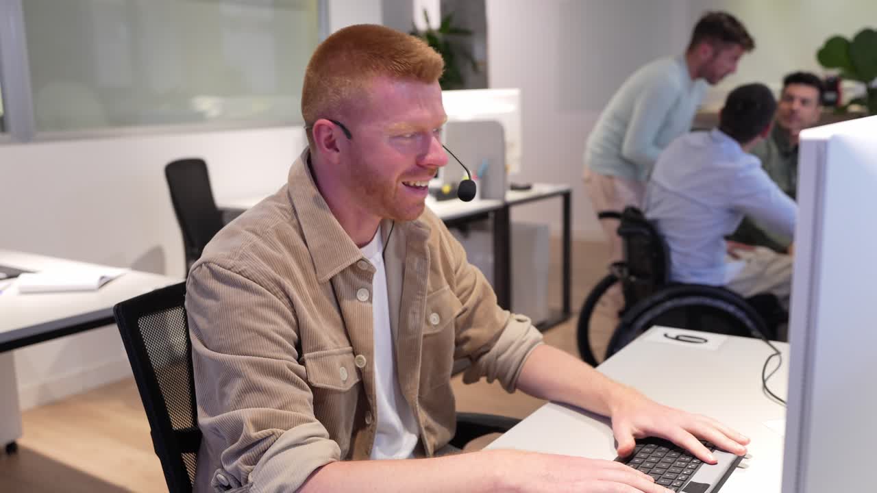 Man working in an office with people in the background