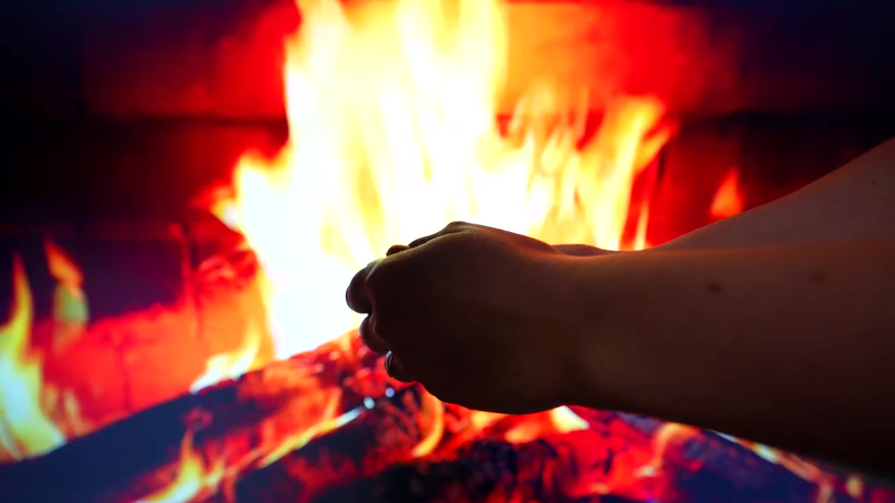 Hands warming by a virtual fireplace in a cozy Christmas setting, 4K