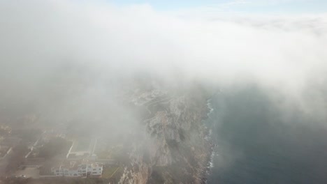 4k drone shot of fog hitting the coastline of the island Mallorca in Spain