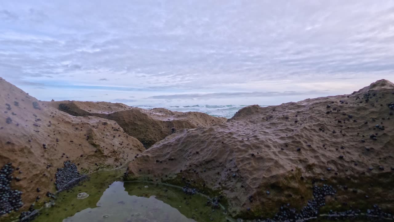 медленные волны над скальными бассейнами и береговой линией