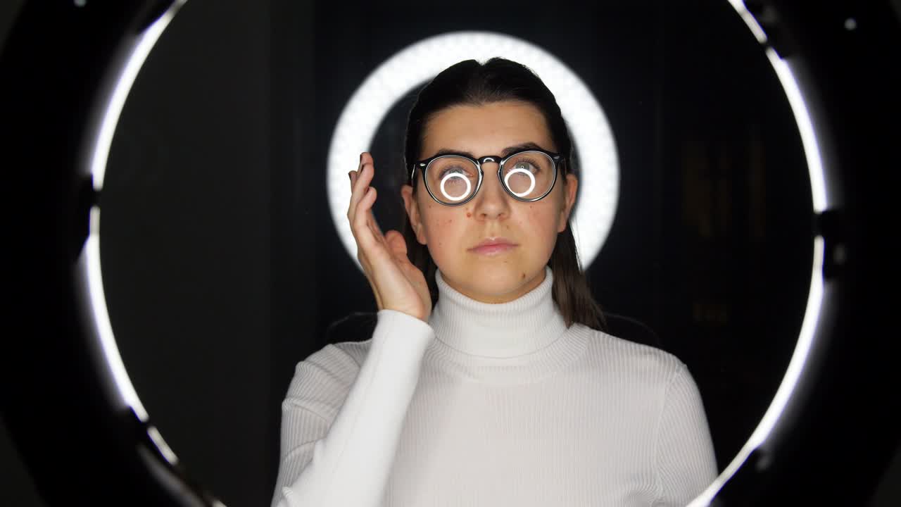 mujer con gafas sobre iluminación blanca en negro