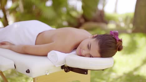 mujer joven disfrutando de un tratamiento de spa al aire libre
