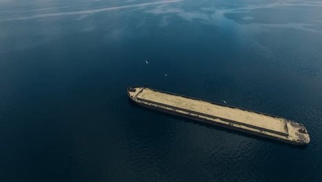 abandoned barge with sand on river. aerial view old barge boat floating
